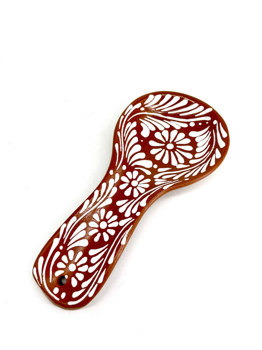 Decorative Talavera spoon rest with floral patterns on a white background