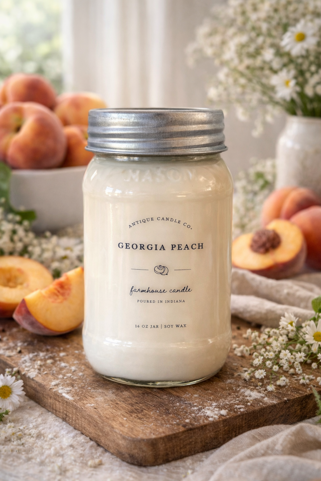 Georgia Peach candle in a glass jar with a metal lid on a wooden board, surrounded by peaches and flowers.