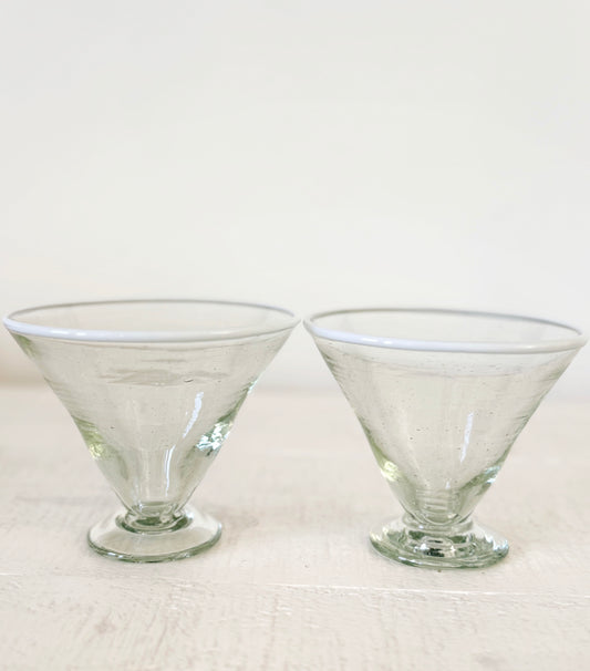 Two clear glass margarita glasses on a white background