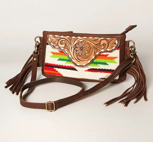 Brown leather handbag with colorful pattern and tassels on a white background