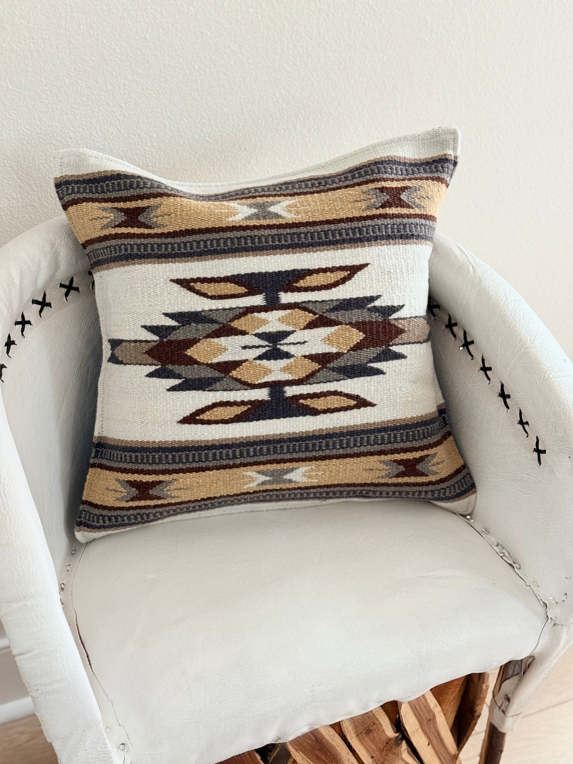 Decorative pillow with geometric pattern on a white chair
