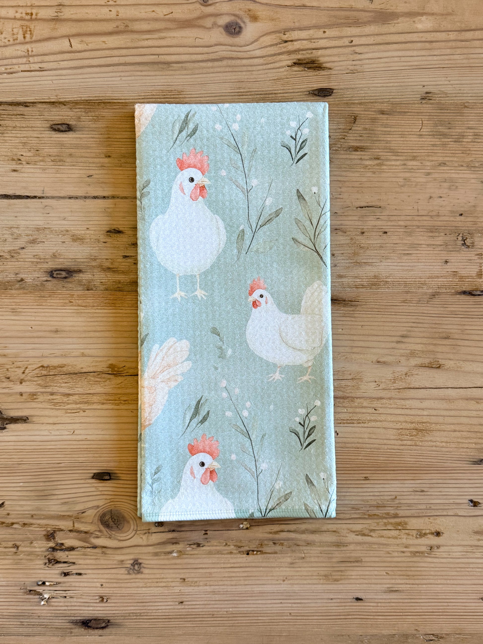 Sage green chicken kitchen towel with white and tan hens and botanical print