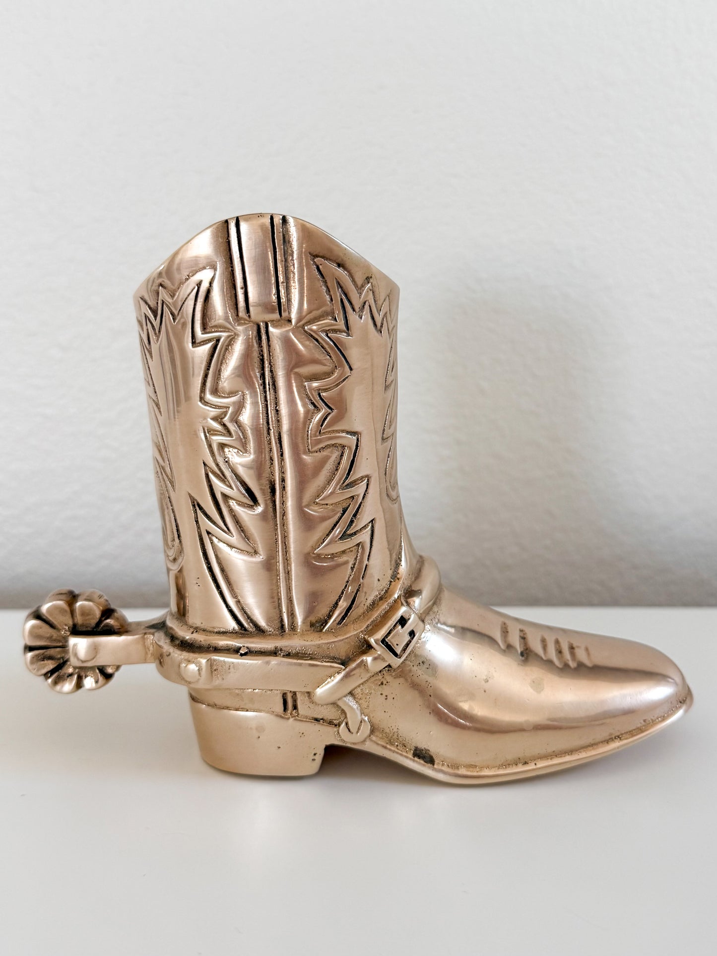 Vintage brass cowboy boot figurine with engraved Western design and spur