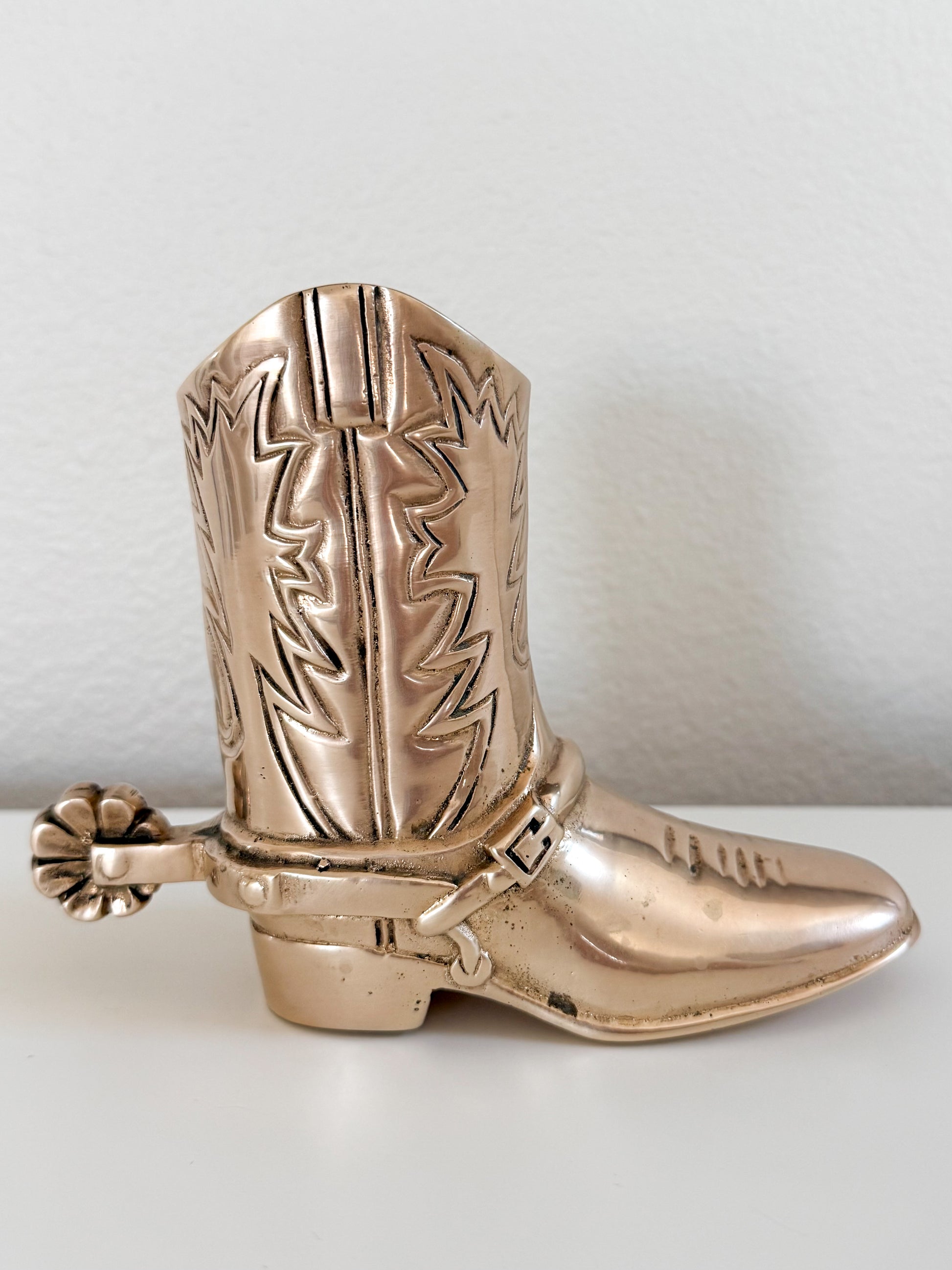 Vintage brass cowboy boot figurine with engraved Western design and spur