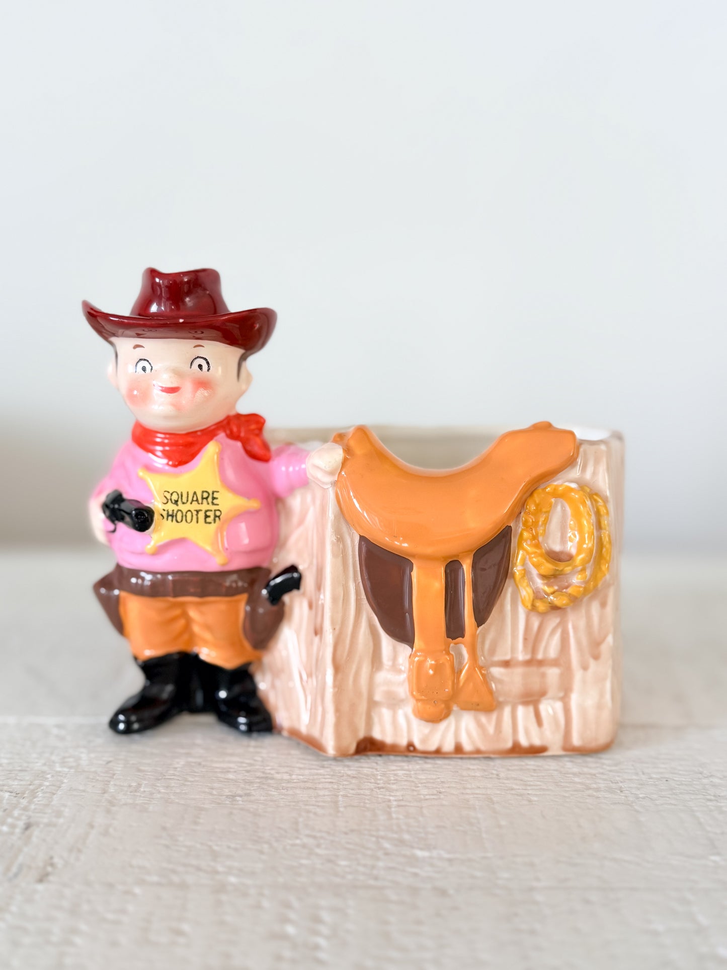 Vintage ceramic cowboy planter with Square Shooter sheriff, saddle and lasso Western design