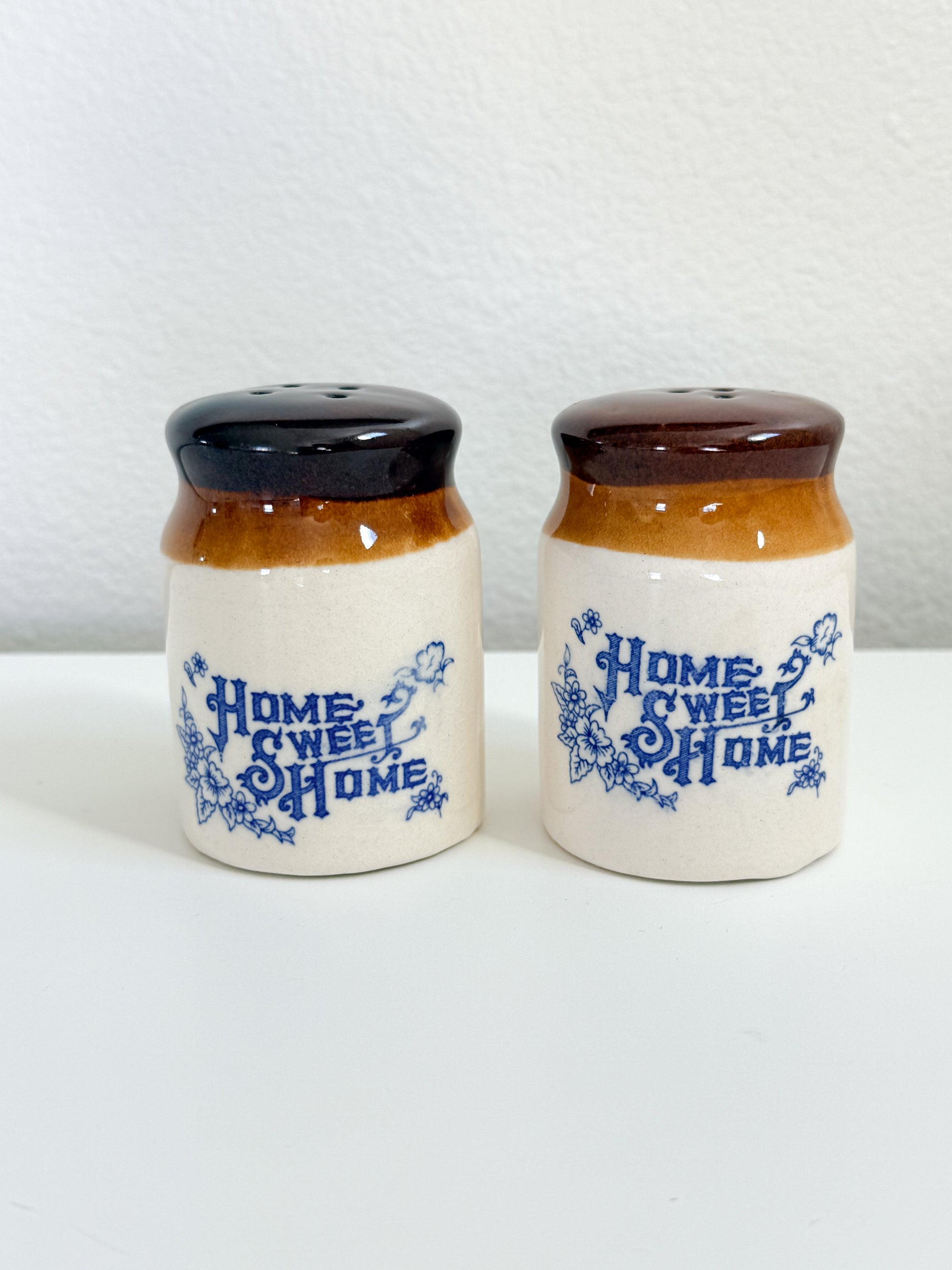 Vintage Home Sweet Home stoneware salt and pepper shakers with blue floral design and brown glazed tops