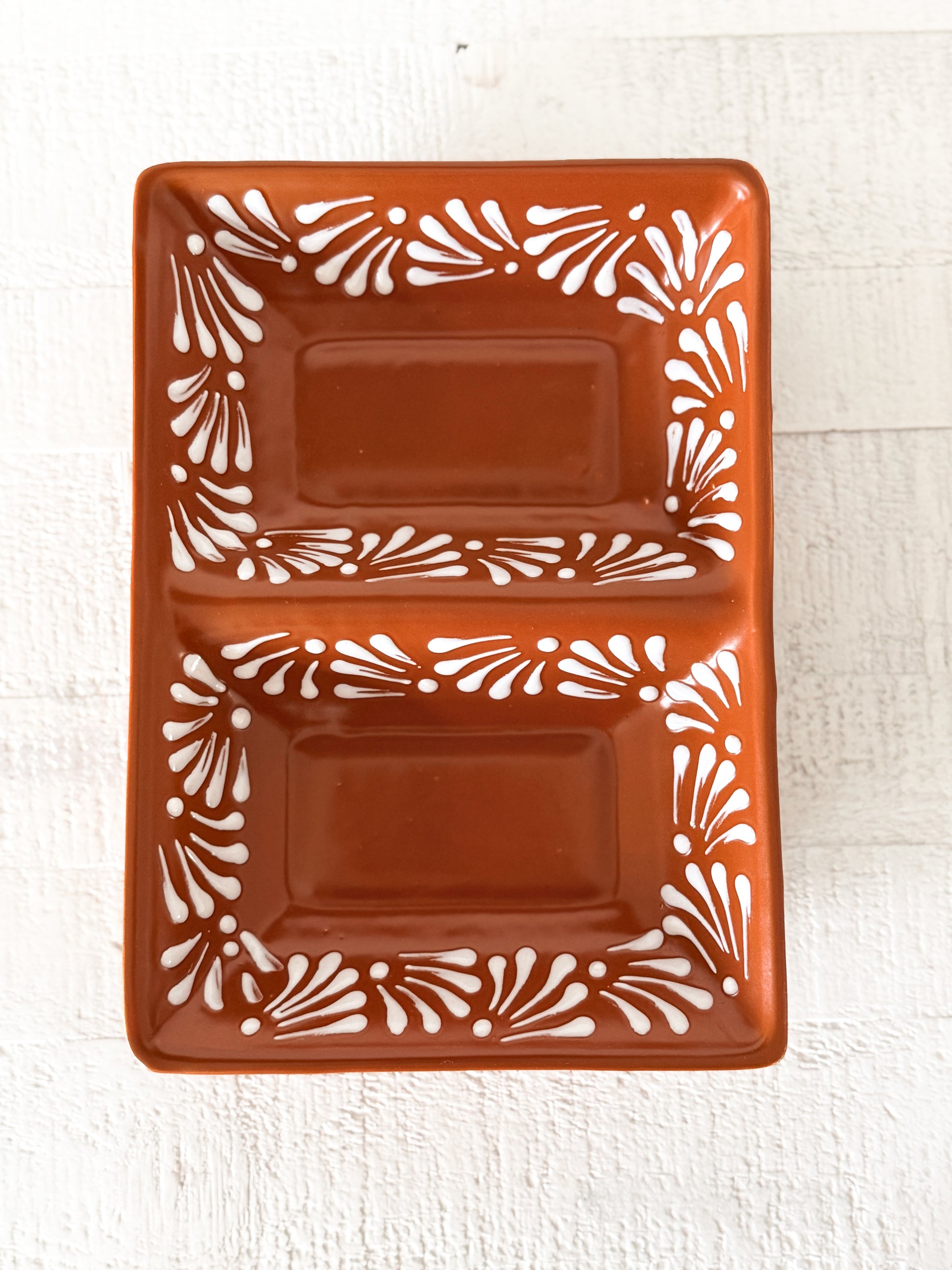 Terracotta brown ceramic divided serving dish with white Southwestern floral design