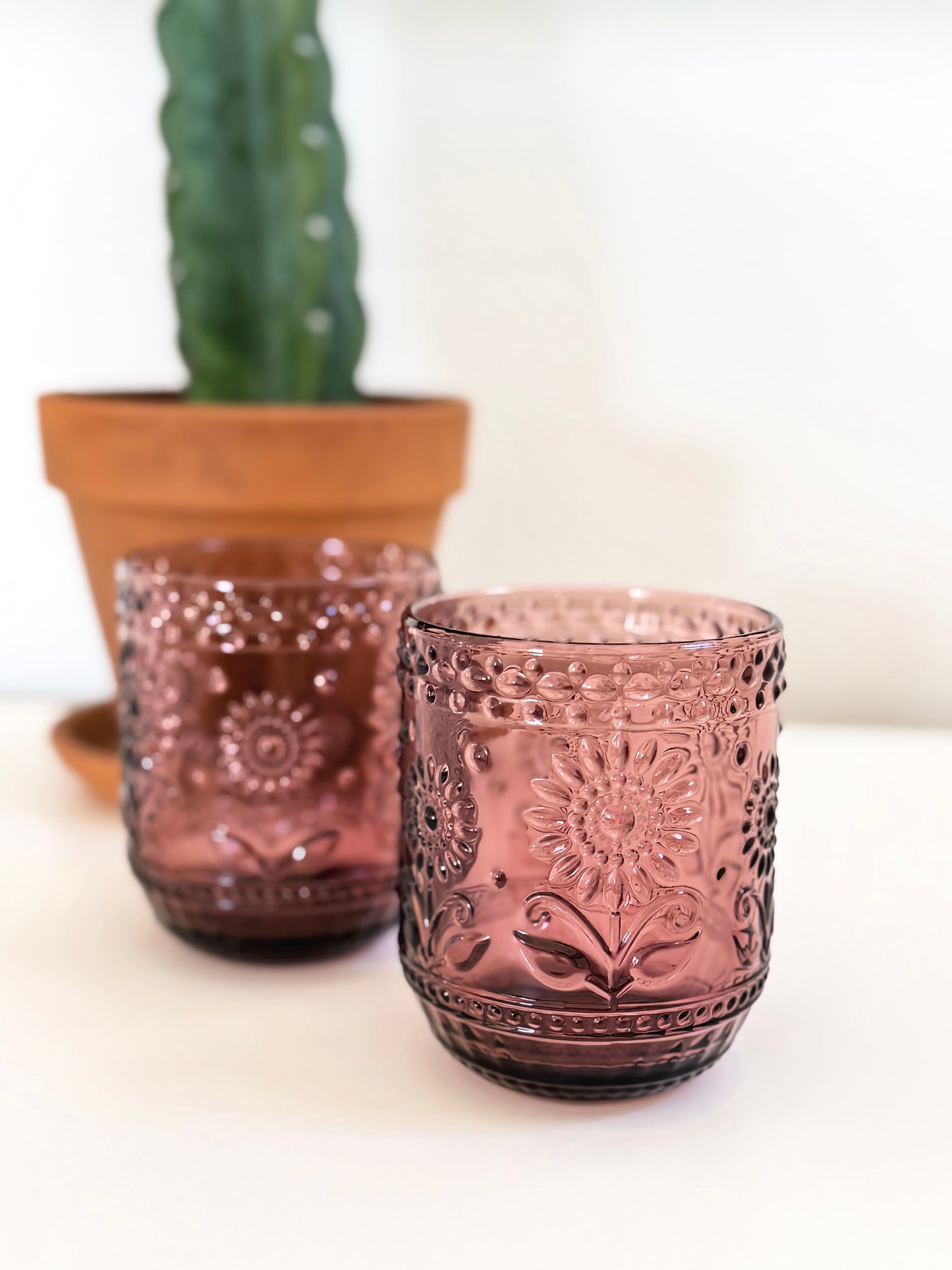 Dusty rose pressed glass tumblers with embossed floral design. Vintage style pink drinking glass.