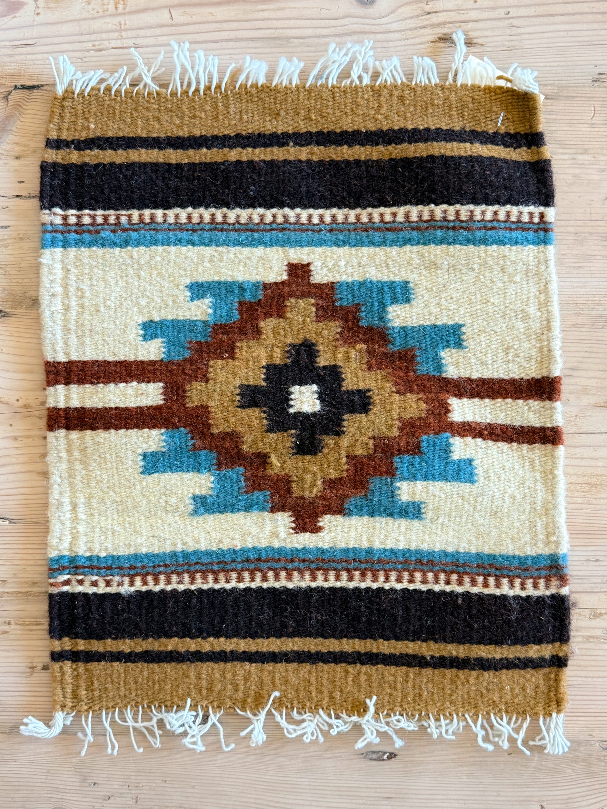Handwoven wool Southwest table mat with turquoise, rust, cream, tan and brown diamond design