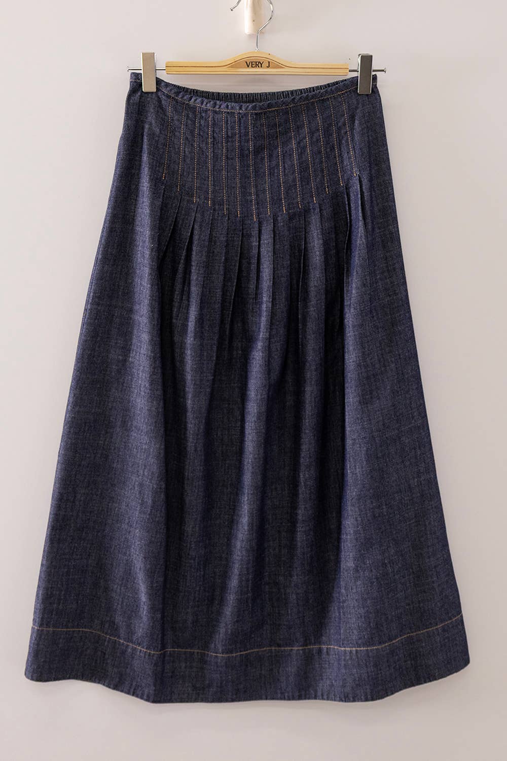 Dark washed denim midi skirt with pleated front and A-line silhouette